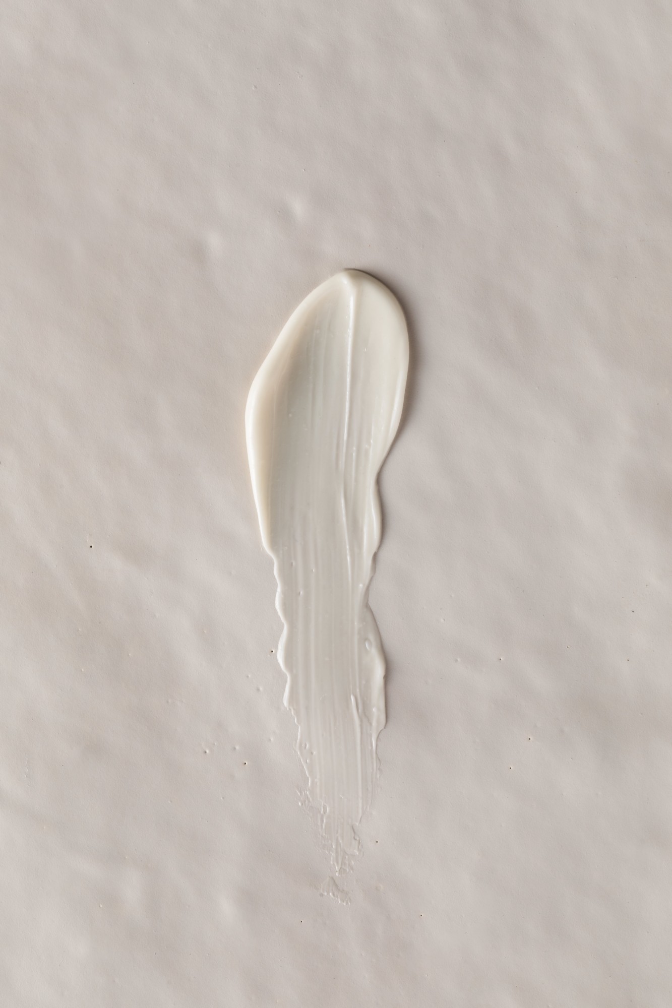 A single swatch of white cream on a neutral background